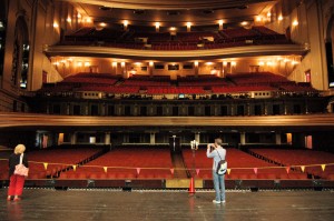 Standing on the front of the stage facing the audience